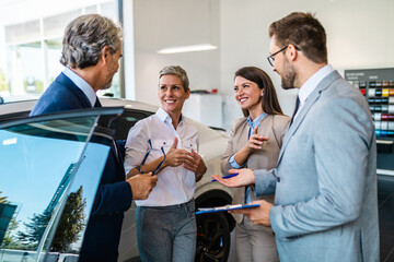 Beautiful couple choosing a new car at car showroom.