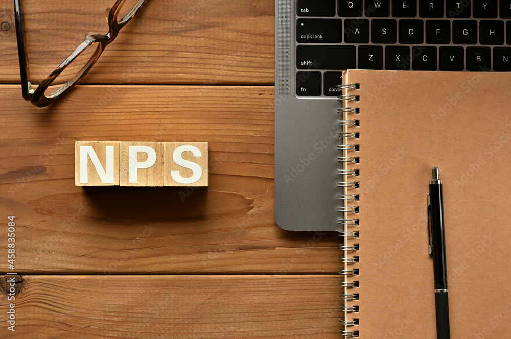 Poster on the table there is a word cube lined nps with laptop computers and glasses. it is an abbreviation