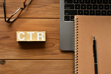 On the table there is a word cube lined CTR with laptop computers and glasses. It is an...