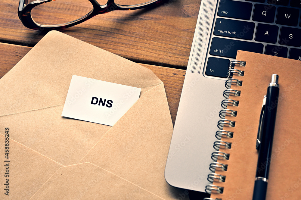 Poster there is a laptop, a pen, an envelope, and a card with dns which is an abbreviation for domain name 