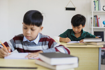 Fototapeta na wymiar Serious Asian students doing exam in a classroom