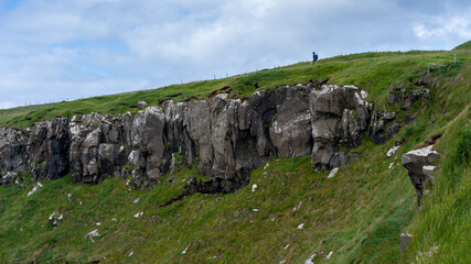 View of a tourist hiker on a beautiful landscape in the mountains of the Faroe Islands