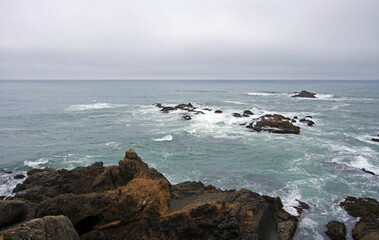 Fototapeta na wymiar Cliffs and rocks at the rough and wild central California Pacific ocean coast around pigeon point on a foggy summer day