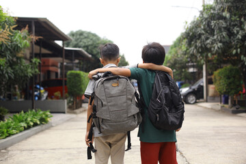 Back view of two students embrace each other going to school