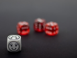 red dice and white dice with emoticon symbols on black background