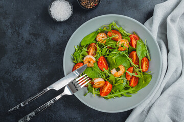 Salad of shrimp prawn and fresh vegetable, leaves of arugula, lettuce.