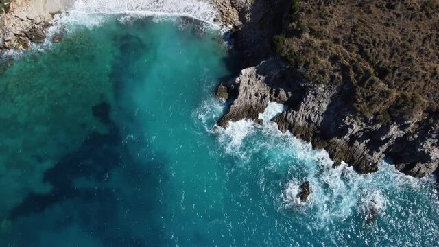 Aerial drone view of rocks, beaches and blue sea. Rocky shore seascape in summer. Crystal clean sea water. Coastline. Ionian sea near Ksamil in Albania.  