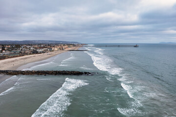 Aerial view of jetties and Imperial Beach Pier daytime drone shot