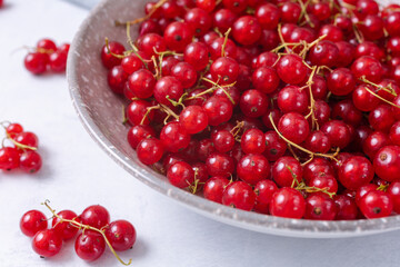 Fresh red currant in wooden bowl on grey table