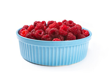 Red raspberry berry in plate on wooden table.