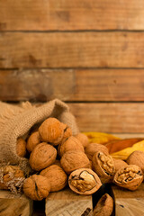 canvas bag with walnuts on wooden background, autumn harvest concept, healthy food, thanksgiving and fall background. 