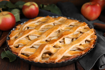 Delicious traditional apple pie on wooden table, closeup