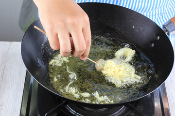 Female Chef Making Cilor or Aci telor, Street Food Snack Made from Tapioca Flour, Coated with Egg. Deep Fried. Selected Focus