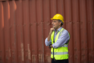 A portrait of a man working in a safety suite working in a port warehouse.