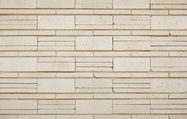 Fototapeta premium Modern champagne beige stone wall texture background. Stylish brick wall backdrop.