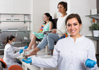 Portrait of happy american professional nail master at working place inviting to salon