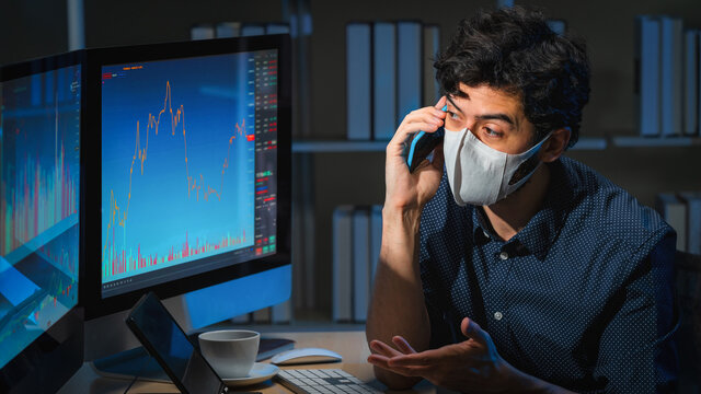 inancial executive with mask talk via smartphone at financial advisor office