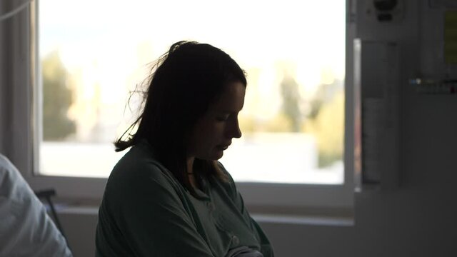Tired woman in hospital room preparing to give a birth, motion view