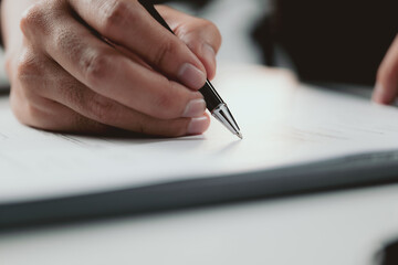 Signing contract. Closeup Businessman signing a contract investment professional document agreement on the table with pen.