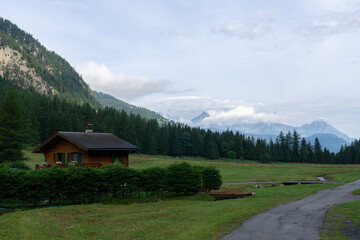 A village with beautiful view on European Alps in the distance. Road among the nature