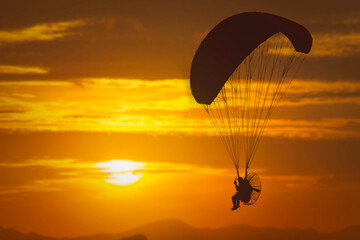 silhouette of paramotor sunset background