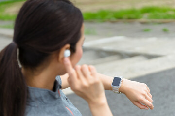 スマートウォッチを見てランニングをする女性（音声操作）