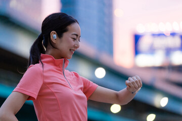 スマートウォッチを操作するスポーツウェアの女性