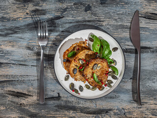 Lunch with pork chops and spices on a light plate and cutlery
