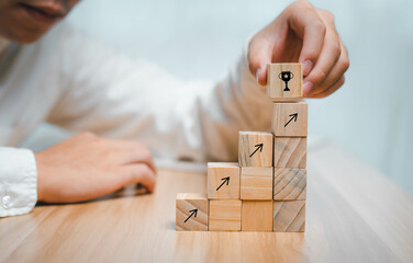 Business men use their hands to stack wooden dice to find profits and investments, plan marketing...