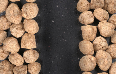 Fototapeta na wymiar Raw soya chunks on dark background. Healthy, nutritious soybean meat, chunks isolated.Vegan food concept.