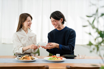 自宅でゆっくり昼食を楽しむ夫婦（ホームパーティ・おうち時間）