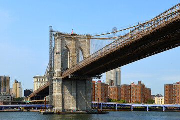 Brooklyn Bridge (1883), hybrid cable-stayed, suspension bridge, against blue sky in New York City....