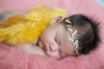 A cute newborn boy wearing a headband and small angle wing sleeping on a pink soft blanket, Infant, babyhood concept and copy space - Image