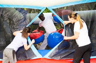Adult fun friends box in huge boxing gloves in an amusement park. High quality photo