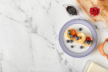 Plate with tasty cottage cheese pancakes and berries on table