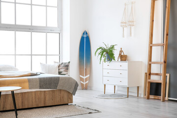 Interior of modern stylish bedroom with surfboard