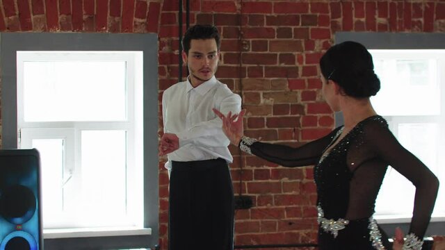 Latin dances - a couple training their dance in the studio with brick walls