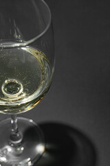 Glass of white wine on dark background, closeup
