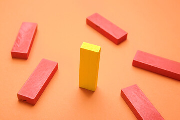 Yellow block among red ones on color background. Concept of uniqueness