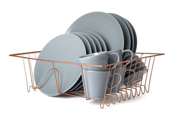Set of clean dishes in drainer on white background
