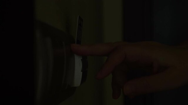 unrecognizable woman puts a key card in a switch in a hotel room. Close-up of hand inserting key card to turn on light in hotel room.