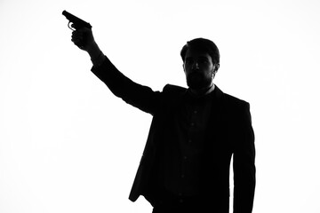 The man in a suit with a pistol in hand crime hand gesture light background