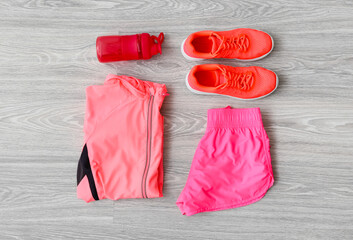 Sportswear, bottle for water, shoes and towel on light wooden background