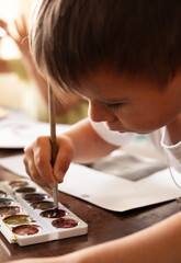 the child draws with scribbles on a white sheet of paper. child development, art development, child development, artistic development of the child concept.