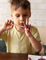 the child draws with scribbles on a white sheet of paper. child development, art development, child development, artistic development of the child concept.