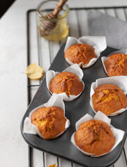 carrot muffins with honey on a light background. organic food, proper nutrition, farm products, diet food, autumn menu, holiday concept