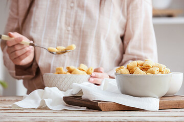 Bowl with tasty corn pillows on wooden table