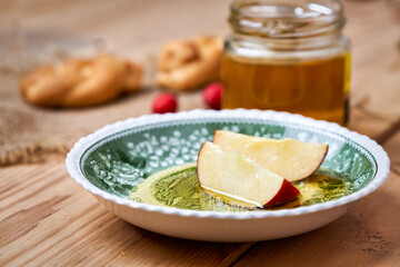 Apples and jar of honey on wooden table. A snack eaten by jews in the holiday of Rosh Hashanah