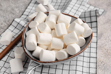 Bowl with tasty marshmallows on light background