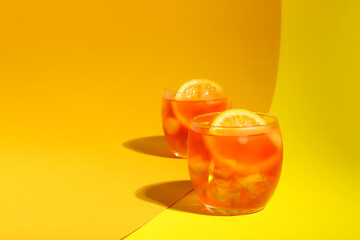 Glasses of Aperol spritz cocktail on color background
